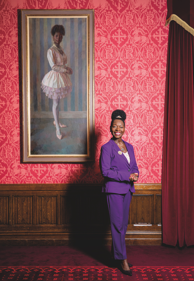 Baroness Floella Benjamin in front of her portrait by the artist June Mendoza 